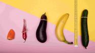 Picture of a range of vegetables in condoms on a pink and yellow background with a tape measure